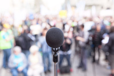 Close-up of microphone with crowd in background