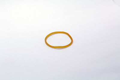 High angle view of yellow ring against white background