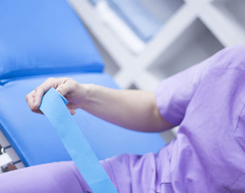 Midsection of doctor holding bandage in hospital