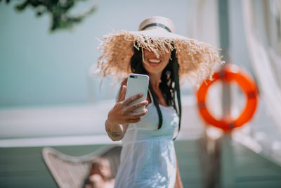 Midsection of woman photographing with mobile phone