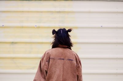 Rear view of woman standing against shutter