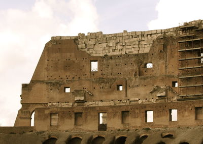 Low angle view of historic coliseum against sky