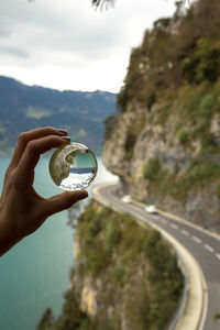 Hand holding crystal in front of a famous road