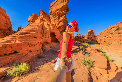 Man on rock formations against sky