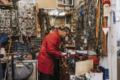 Side view of male locksmith working in repair shop