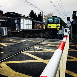 Train at railroad station in city against sky