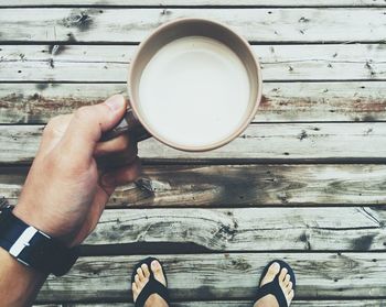 Directly above of man holding coffee cup