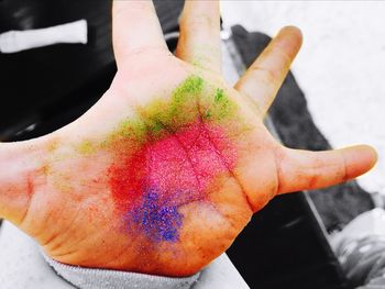 Close-up of human hand holding multi colored blurred background