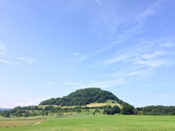 Scenic view of grassy field against cloudy sky