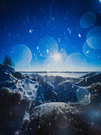 Digital composite image of sea against sky at night