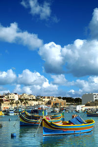 Boats moored in sea against buildings in city