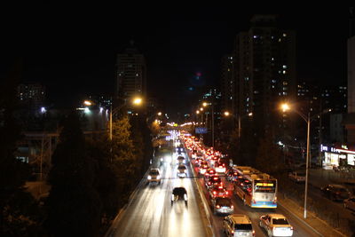 High angle view of traffic on road amidst buildings at night