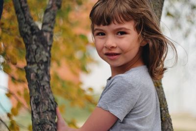 Portrait of girl against tree