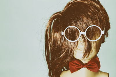 Close-up of girl wearing sunglasses against white background