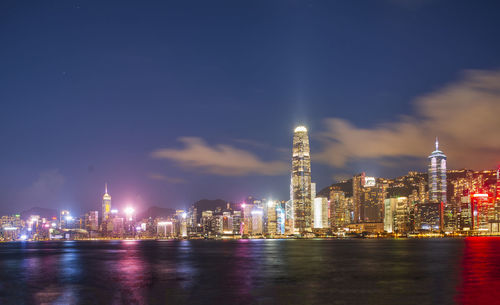 Illuminated buildings in city against sky at night