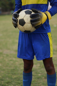 Low section of man playing soccer at park