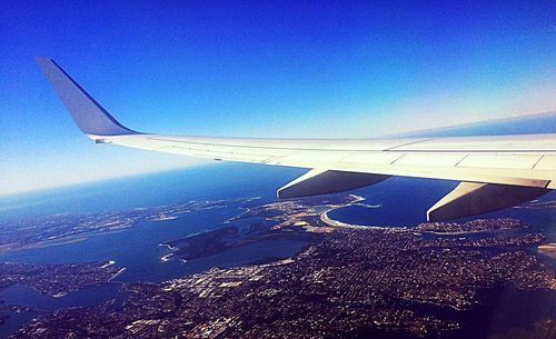 Low angle view of airplane wing over landscape