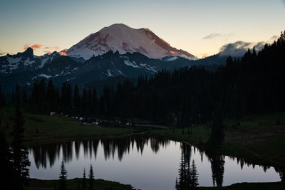 Scenic view of lake and mountains against sky during sunset