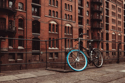 Bicycle parked on footpath by building in city