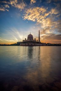 Built structure in water at sunset