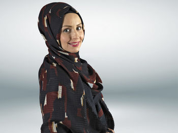 Portrait of young woman against white background