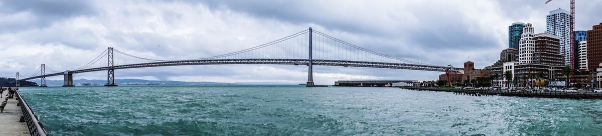 View of suspension bridge against cloudy sky