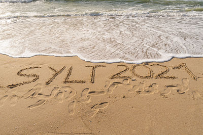 High angle view of text on sand at beach