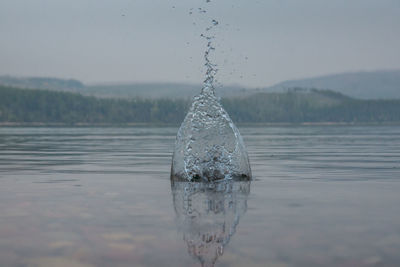 Close-up of water drop against sky