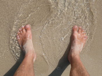Low section of person on wet sand