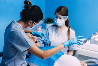 Dentist operating pregnant woman in medical clinic