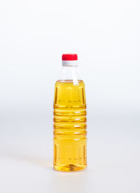 Close-up of cooking oil in bottle over white background