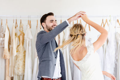 Young couple looking away while standing against wall