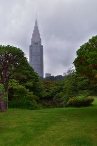 View of trees and buildings against cloudy sky