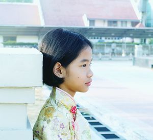 Side view of girl standing on footpath