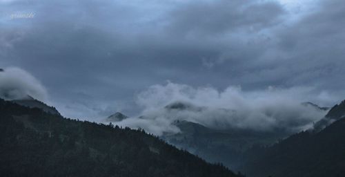 Scenic view of mountains against cloudy sky