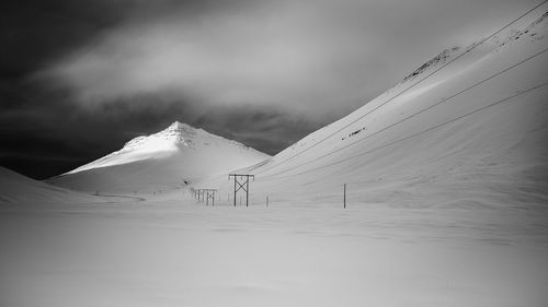 Snowcapped mountains against cloudy sky