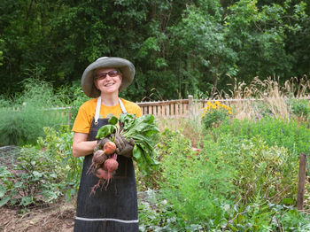 Portrait of smiling woman standing against plants