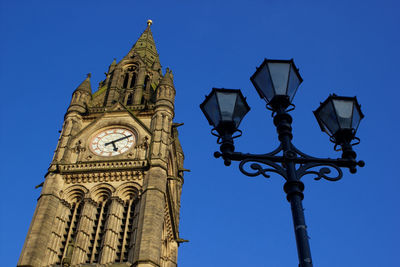 Low angle view of clock tower against blue sky