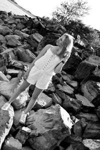 Young woman on rock against sky