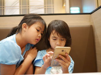 Girl with sister using phone
