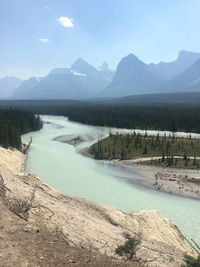 Scenic view of lake by mountains against sky