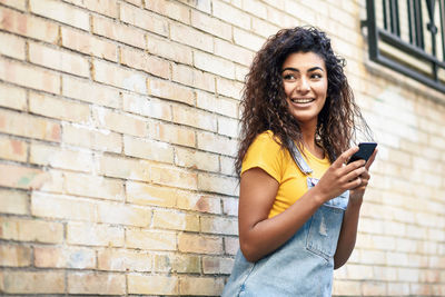 Portrait of smiling young woman using smart phone