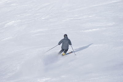 Rear view of man skiing on snow covered land