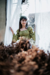 Portrait of asian woman relaxing standing in a greenhouse flower garden, close up.