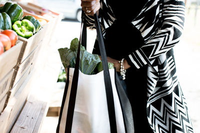 Midsection of woman shopping at market stall