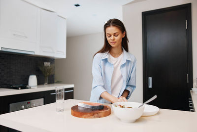 Young woman using laptop while sitting on table