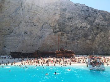 View of people at beach against mountain