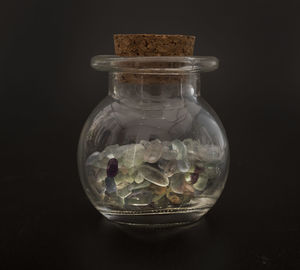 Close-up of medicines in glass jar against black background