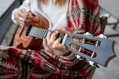 Midsection of woman playing guitar