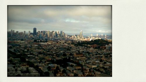 Cityscape against cloudy sky